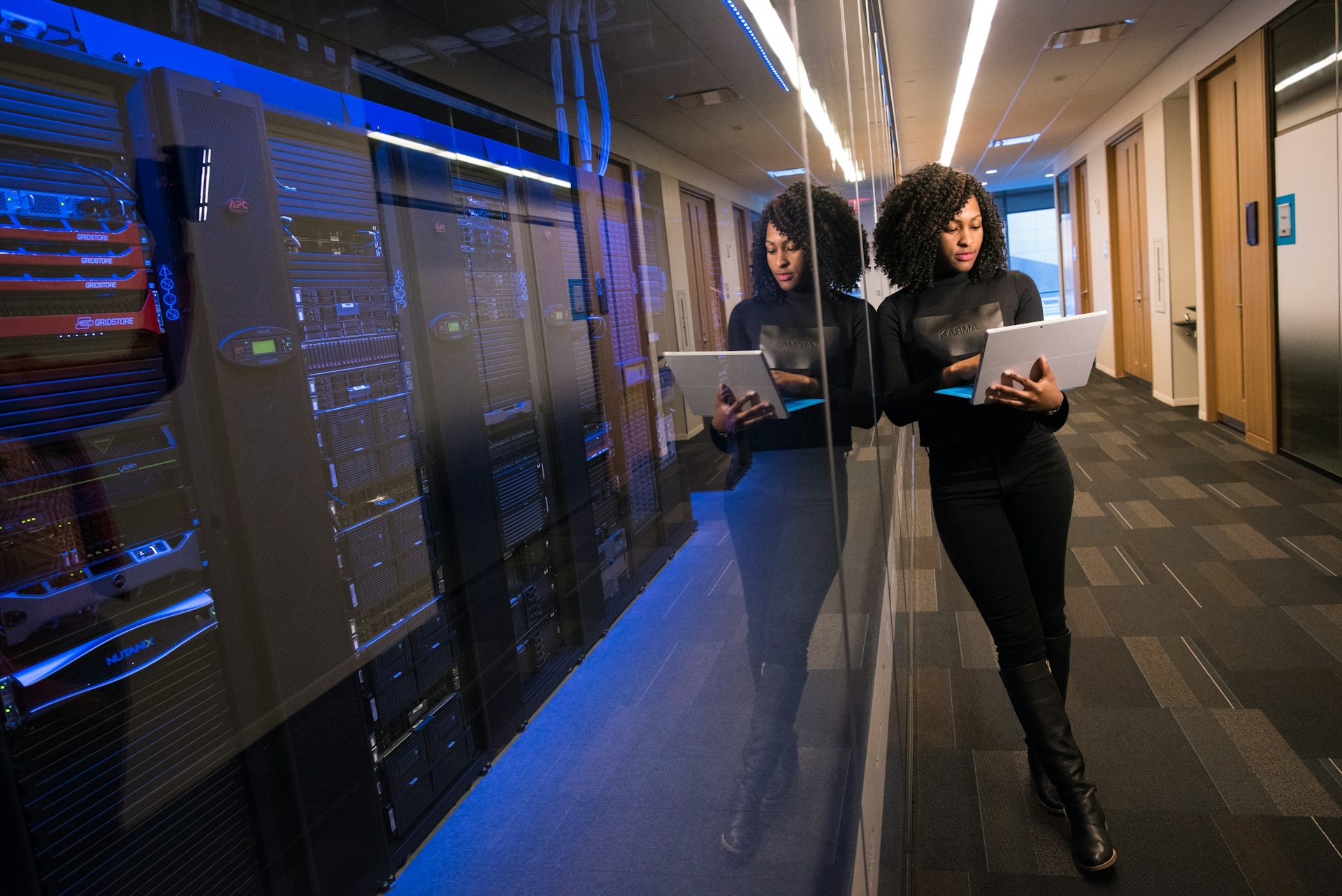 A women stands next to a database, managing sql server farms